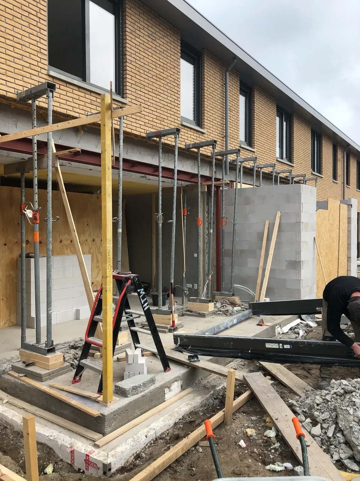 Deuropening in een aanbouw tijdens de ruwbouw, met steigers en stempels