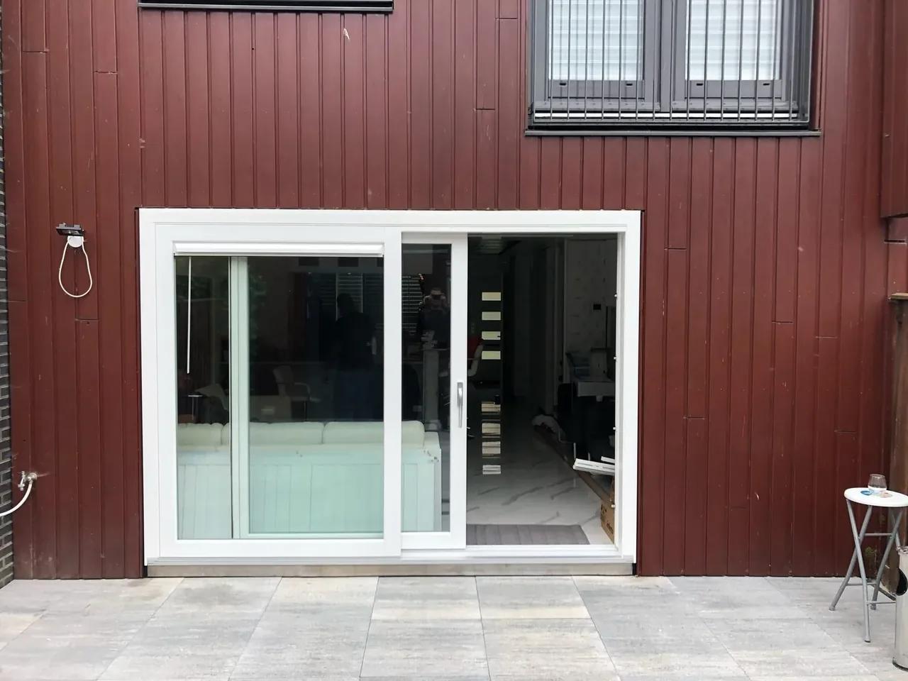 Witte kunststof schuifpui in een houten gevel, geplaatst door ons team